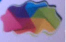 Forma abstracta con cinco secciones de colores: rosa, morado, azul, verde y amarillo.