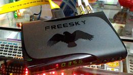 Decodificador preto "Freesky" com display digital, cabos conectados.