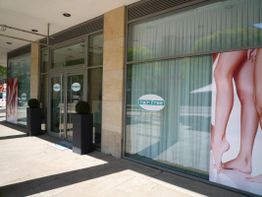 Geschäftsfassade mit großen Fenstern und Plakaten von glatten Beinen, beschriftet mit "hair free".