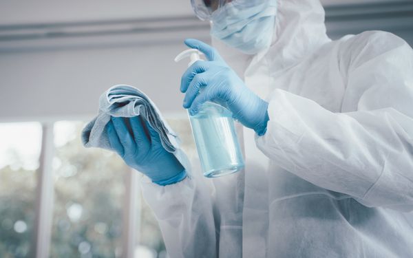 Krankenhausmitarbeiter desinfiziert Kontaktflächen mit einem speziellen Reinigungsmittel und einem Mikrofasertuch.