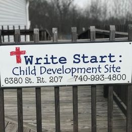 Sign reads "Write Start: Child Development Site," with contact details and a red cross.