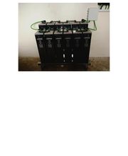 Baterías de emergencia conectadas con cables verdes en una pared blanca.