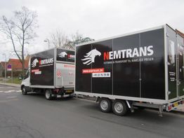 Lastbiler fra Nemtrans parkeret på en vej i et beboelsesområde.