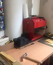 Arbeitsplatz mit roten Werkzeugen, Schlüsselwand, Hammer und Materialien auf einem Tisch.