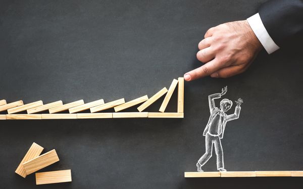 Dominosteine fallen auf Mann, werden jedoch von Versicherung aufgehalten.