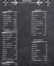 Menú de bebidas en pizarra con precios: cafés, refrescos, cervezas, aperitivos, y brandy.