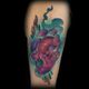 Tatuaje colorido de corazón anatómico en un brazo, rodeado de diseños abstractos y humo.