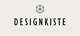 Der Text "DESIGNKISTE" mit einem stilisierten Würfel-Symbol darüber auf hellem Hintergrund.