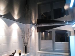 Modernes Badezimmerdesign mit weißen Fliesen, Fenster, Spiegel und dekorativem Zweig in Vase.