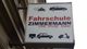 Schild einer Fahrschule mit verschiedenen Fahrzeuggrafiken und dem Text "Fahrschule Zimmermann".