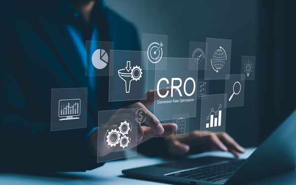Eine Person sitzt vor einer eingeblendeten Grafik die die Komponenten der Conversion Rate einer Landingpage aufzeigen.