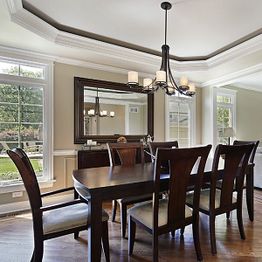Elegant dining room with dark wooden table, six chairs, and a modern chandelier.