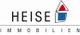 Logo mit Text "HEISE IMMOBILIEN", stilisiertes Haus-Icon mit Dreiecken in Rot und Blau.