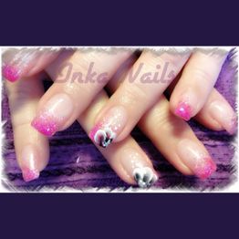 Hände mit rosa Glitzernägeln und Blumenmuster auf lila Hintergrund.