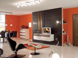 Modernes Wohnzimmer mit orangefarbenen Akzentwänden, schwarzen Möbeln und stilvoller Beleuchtung.