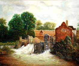 Alte Wassermühle mit rotbraunem Gebäude und großen Bäumen an einem kleinen Fluss im Hintergrund.