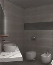 Bagno moderno con lavabo, WC, bidet e vasca. Piastrelle grigie alle pareti.