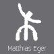 Abstrakte weiße Figur auf grauem Hintergrund, darunter der Text "Matthias Eger".