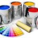 Barattoli di vernice colorata con rullo e ventaglio di colori su sfondo bianco.