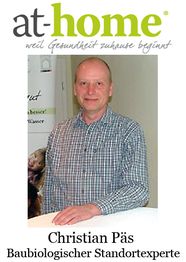 Mann in kariertem Hemd steht vor einem Poster mit at-home-Logo. Text: Christian Päs, Standortexperte.