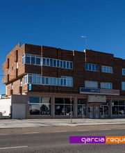 Edificio de ladrillo con ventanas amplias y letrero de "Garcia Reguera SL" en la fachada.