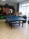 Tischtennisplatte in einem Sportgeschäft mit Sportkleidung an den Wänden.