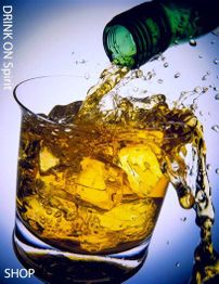 Flasche gießt Whisky in ein Glas mit Eiswürfeln vor blauem Hintergrund ein.