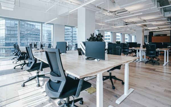 Büroarbeitsplätze mit Tischen, ergonomischen Stühlen und Bildschirmen