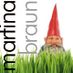 Ein Gartenzwerg schaut aus hohem Gras hervor, daneben steht senkrecht "martina braun" geschrieben.