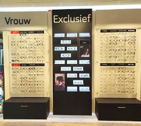 Wand met brillen in een winkelsectie voor vrouwen en exclusieve modellen.