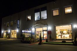 Negozio di mobili illuminato di notte, con ampie finestre che mostrano l'interno arredato.