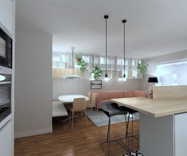 Sala moderna con cocina abierta, isla de madera, lámparas colgantes y sofá al fondo.