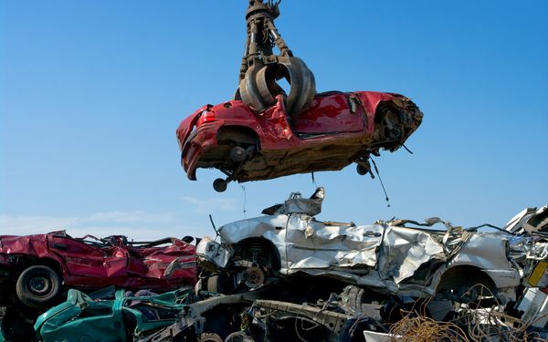 verschrottetes Auto wird auf Autoschrottplatz angehoben