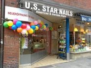 Nagelstudio mit bunten Luftballons zur Neueröffnung, neben einem anderen Geschäft in der Stadt.