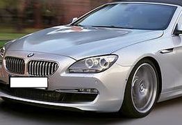 Silberner BMW auf der Straße, Frontansicht mit markantem Kühlergrill und Scheinwerfern.