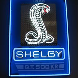 Neon sign with a glowing cobra and the words "Shelby GT 500 KR," bordered by a blue frame.
