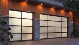 Modern garage with frosted glass doors and wooden panels, illuminated by outdoor lights.