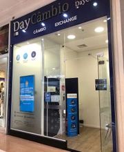 Fachada de uma casa de câmbio chamada DayCâmbio, com vitrines de vidro e sinalização externa.