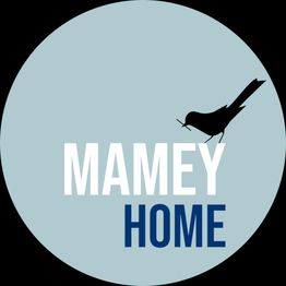 Círculo azul con el texto "MAMEY HOME" y una silueta de pájaro negro.