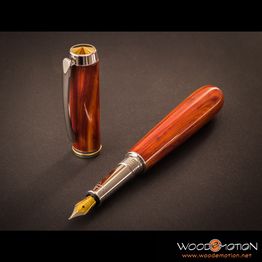 Ein edler Füllfederhalter aus Holz liegt auf dunklem Hintergrund neben der abgenommenen Kappe.