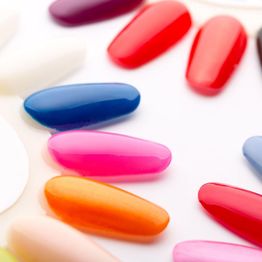 Colorful nail polish samples arranged in a semi-circle on a white background.