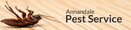 Dead cockroach on wood surface next to "Annandale Pest Service" text.