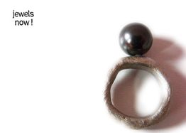 Ein Ring mit einer großen schwarzen Perle und der Schriftzug "jewels now!" auf weißem Hintergrund.