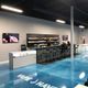 Modern vape shop interior with blue floor, counter seating, and a display of products.