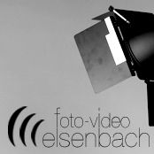 Schwarz-weißes Bild eines Studiolichts mit dem Text "foto-video elsenbach" darunter.