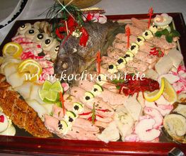 Eine reichhaltige Fischplatte mit verschiedenen Meeresfrüchten, garniert mit Zitronen und Kräutern.