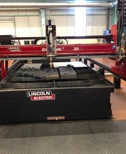 Máquina de corte CNC roja en un taller industrial.