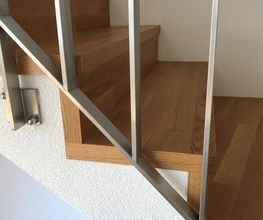 Holztreppe mit Metallgeländer in modernem Design.