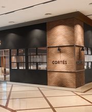 Fachada de restaurante chamado Cortés em um shopping, com decoração moderna de tijolos.