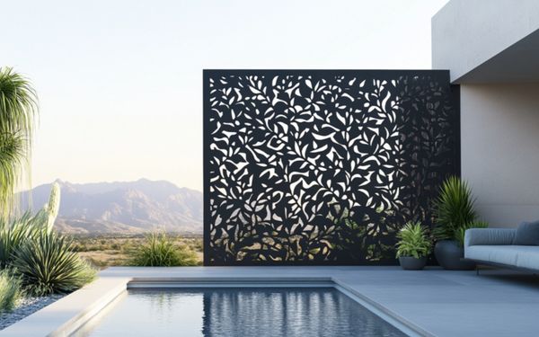 Schwarzer Metall Sichtschutz mit Muster vor einem Pool.